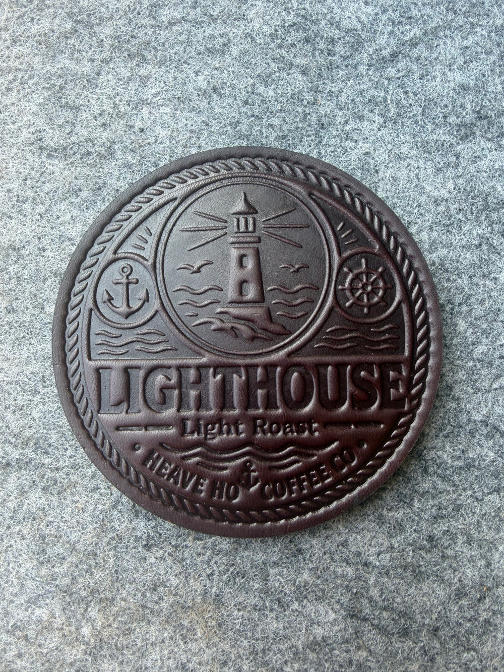 Custom embossed Lighthouse leather coaster for Heave Ho Coffee Co., shown from above