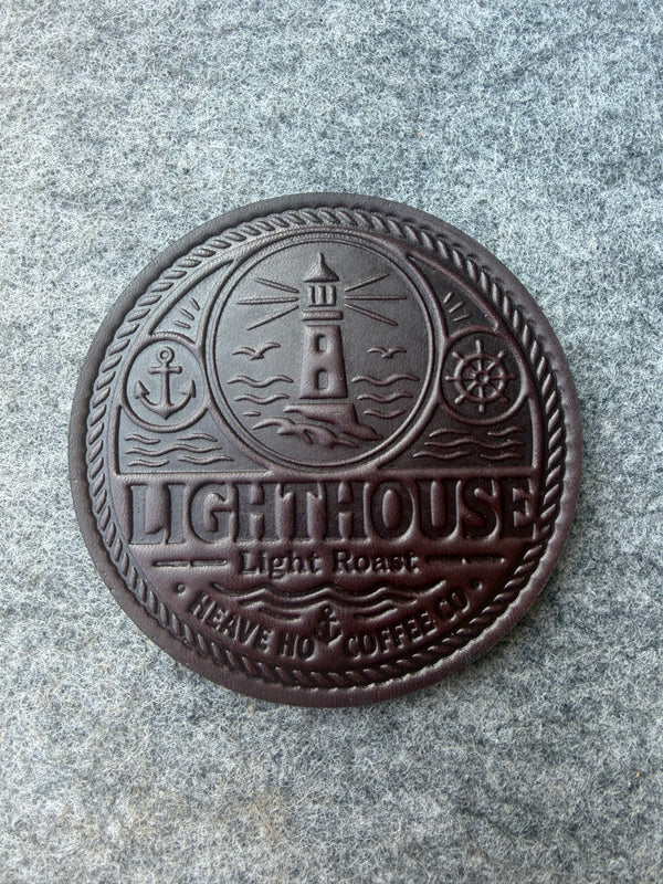 Custom embossed Lighthouse leather coaster for Heave Ho Coffee Co., shown from above